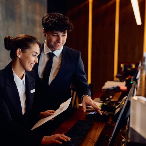 happy receptionists working on a computer at hotel front desk